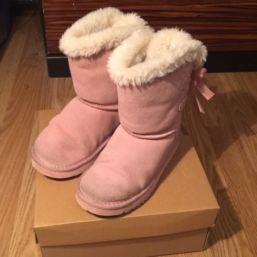 Pink girls Ugg boots with bows, worn